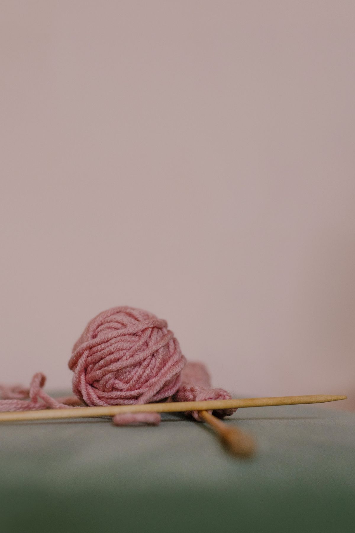 Pelote de laine rose et aiguille en bois